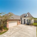 A custom home that has a side entry garage and fenced in backyard.