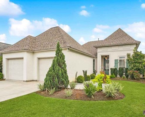 The neutral exterior and green shutters give it timeless Southern charm.