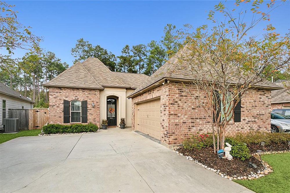 1-3033 Lost Lake Fully Landscaped The arched entryway and neutral garage door complement the rustic brickwork, making this a perfect blend of traditional charm and modern sophistication.