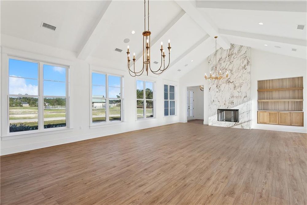 10-Natural Lighting 1174 Audubon Pkwy This expansive great room features soaring vaulted ceilings with exposed beams, creating an open and airy atmosphere perfect for entertaining.