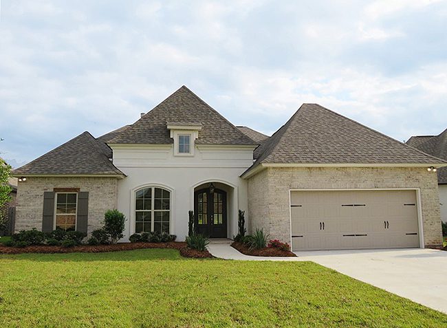 1021 Cypress Crossing Drive is a newly built home with stucco exterior and brick accent. There is a two care garage with one large door. A ranch home with a dormer window giving it a two story appearance.