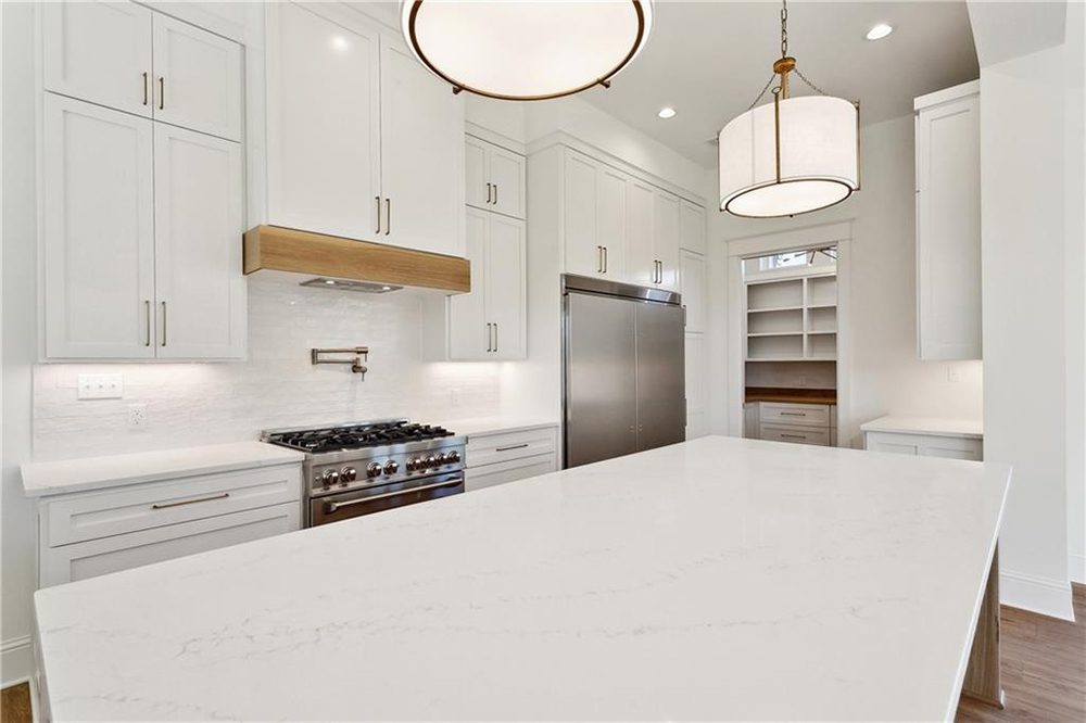 11-Custom Cabinets 1174 Audubon Pkwy This luxurious kitchen showcases a sleek, modern design with crisp white cabinetry that stretches to the ceiling, offering ample storage and a clean aesthetic.