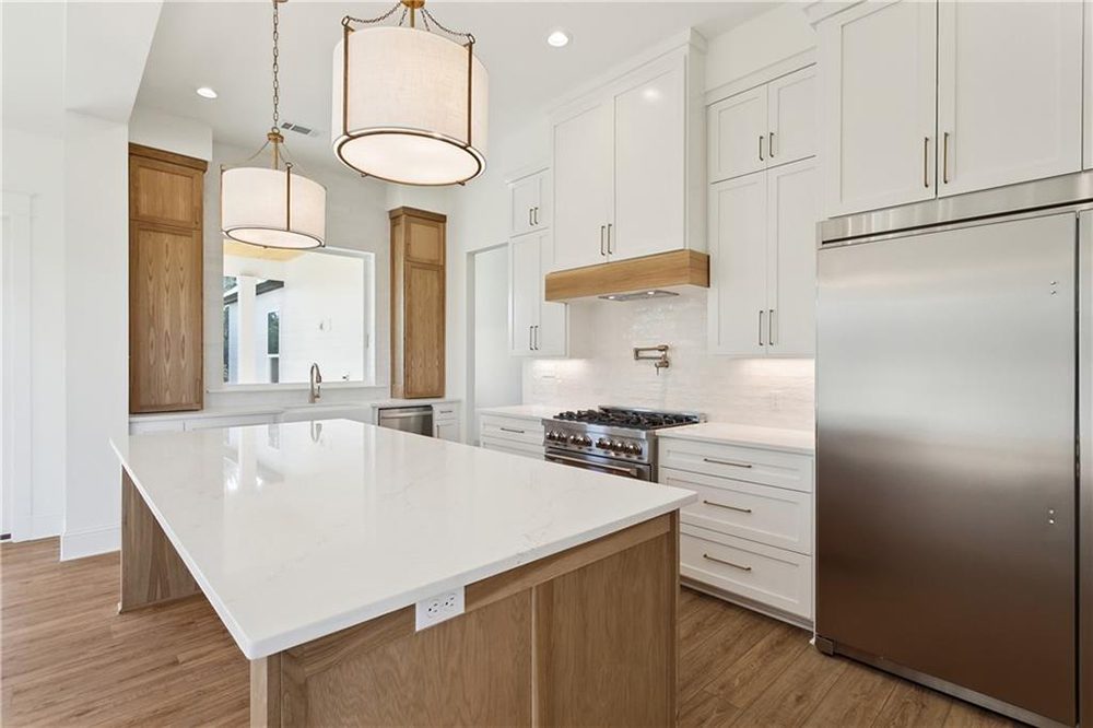 14-Custom Appliances 1174 Audubon Pkwy This kitchen showcases a bright, modern design with a large quartz island that offers generous prep space and seating.