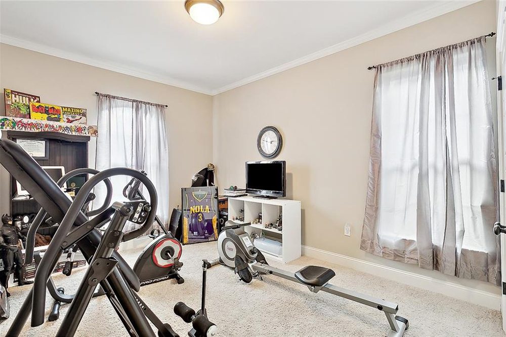 16-3033 Lost Lake Bonus Room WIndow A white entertainment center with a mounted TV, sports memorabilia, and a bookshelf filled with collectibles and comic-themed decor add personality to the space.