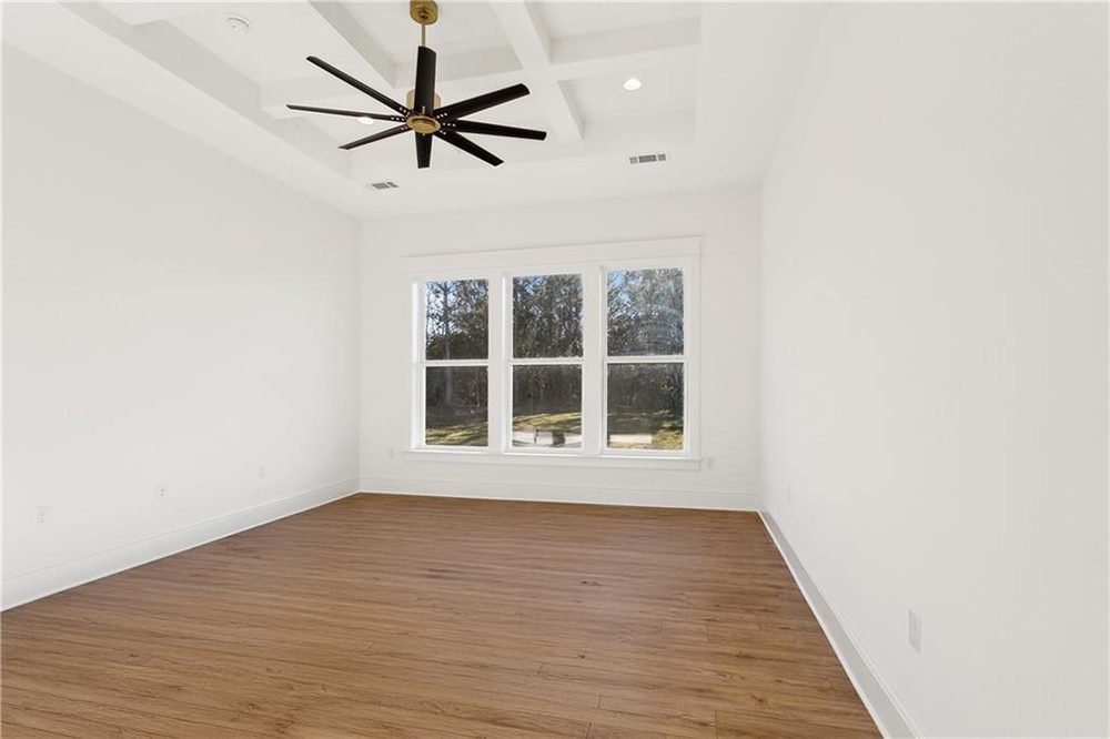 16-Master Bedroom 1174 Audubon Pkwy Expansive windows allow natural light to flood the space, highlighting the warm wood floors and clean white walls for a crisp and serene atmosphere.