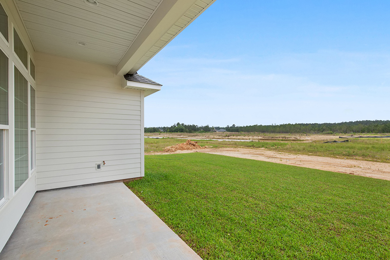 Green backyard with a great view. This new home has a covered porch. A great feature for outdoor entertainment.