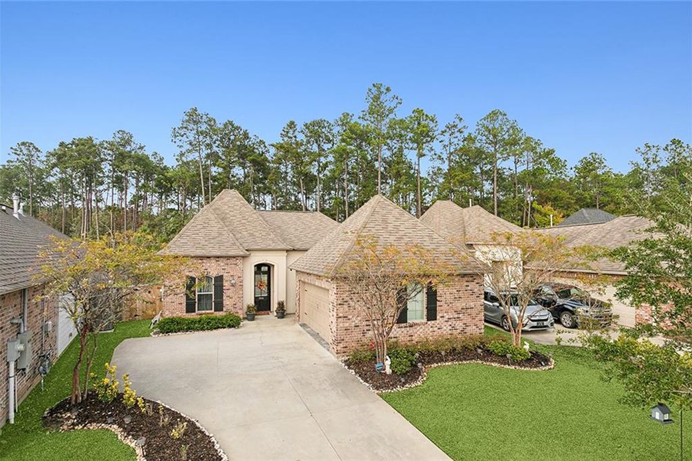 2-3033 Lost Lake Above View This stunning French Country-style home boasts a beautifully crafted brick exterior with warm, earthy tones that create a timeless and inviting look. The architectural design features elegant hip roofs and a charming arched entryway, which is complemented by soft beige stucco accents. Classic black shutters enhance the traditional aesthetic, while the neutral-toned garage door blends seamlessly with the brickwork. The well-manicured landscaping includes lush greenery, neatly edged flower beds, and a curved driveway that enhances the home’s curb appeal. Set against a serene wooded backdrop, this home offers a perfect blend of rustic charm and modern elegance, making it an ideal choice for those who appreciate classic yet refined architecture.