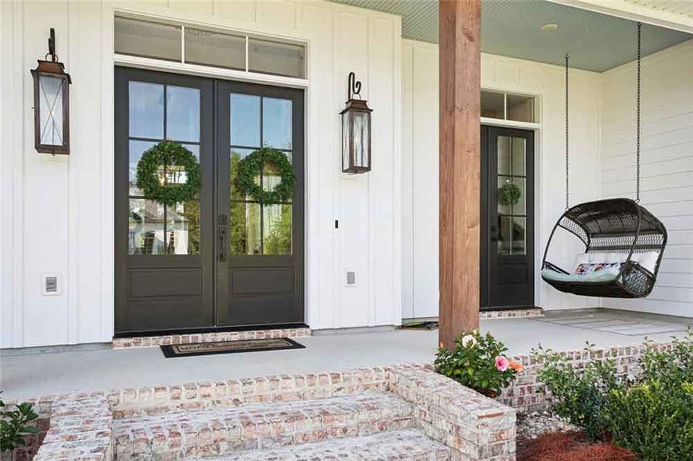 A cozy hanging chair swing and rustic brick steps add both style and comfort, creating an inviting first impression for guests.