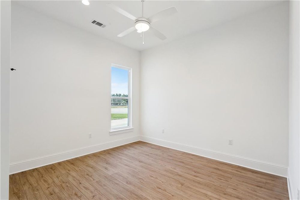 20-Bedroom 1174 Audubon Pkwy A sleek white ceiling fan with a built-in light fixture offers comfort and energy efficiency, while recessed lighting ensures the room stays well-lit at all hours. Simple baseboards and understated trim work maintain the room’s streamlined and modern appeal.