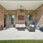 Covered patio that looks out onto the spacious fenced-in backyard. This patio is complete with a ceiling fan and custom lighting.
