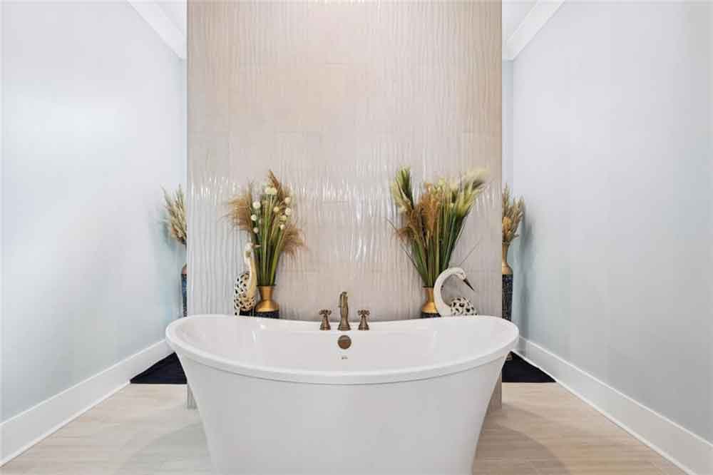 Flanking the tub, tall decorative vases filled with natural pampas and greenery create perfect symmetry and a sense of calm. The combination of clean lines, organic textures, and gentle lighting makes this space ideal for unwinding and rejuvenating — a true sanctuary within the home.