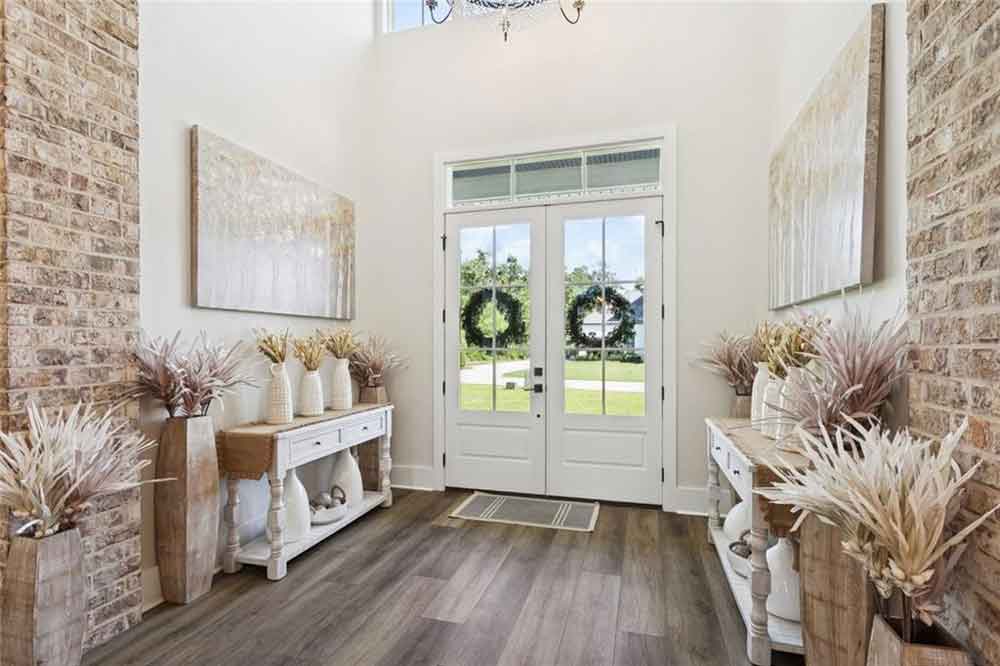 The space is styled with matching console tables and decorative vases, offering a warm and elegant welcome into the home.