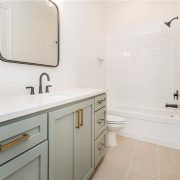 Beautiful subway tile surrounds the shower tub combo and compliments the vanity counter.