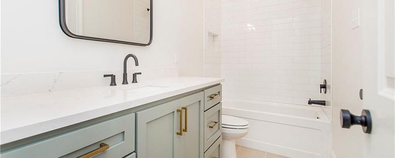 Beautiful subway tile surrounds the shower tub combo and compliments the vanity counter.