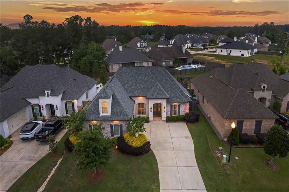 33-1104-Cypress-Crossing-Drive A beautiful sunset casts light on the roofline, driveway, and welcoming neighborhood.