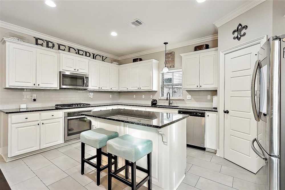4--3033 Lost Lake Kitchen Thoughtful details like crown molding, decorative accents above the cabinets, and a French-style pantry door add character, making this kitchen both functional and visually stunning.