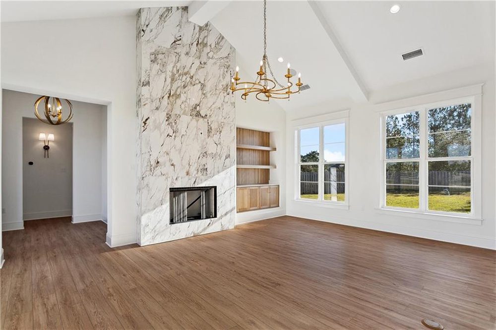 4-Marble Mantel 1174 Audubon Pkwy Natural light pours through oversized windows, illuminating the warm wood flooring and custom built-in shelving that offers both style and functionality.