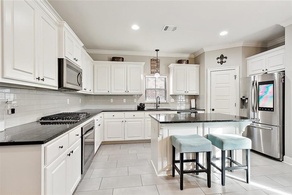 5--3033 Lost Lake Custom Kitchen Cabinets Soft pendant lighting over the sink and recessed ceiling lights create a warm, inviting atmosphere, while the neutral-toned walls and light tile flooring maintain a sophisticated and airy feel. With its timeless charm and contemporary updates, this kitchen is the perfect balance of beauty and practicality.