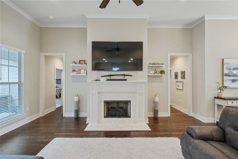 This family room has a nice fireplace. The home has nice hardwood flooring.