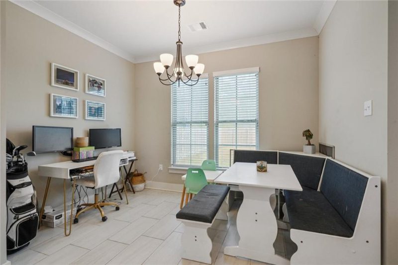 The breakfast area in this open floor plan is used for an eating area and a home office area.