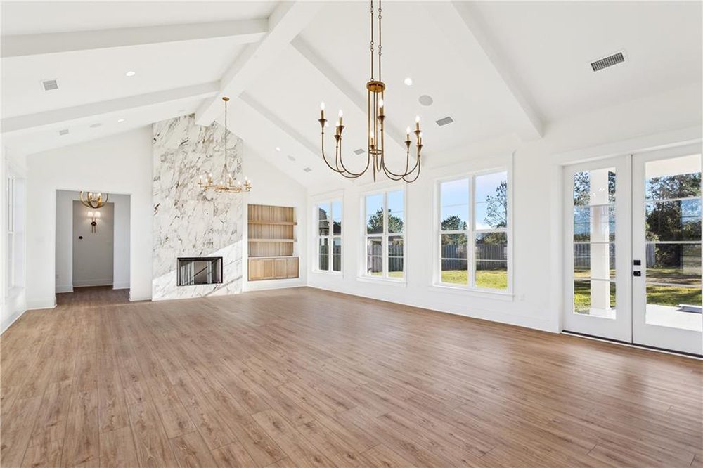 9-Vaulted Ceiling 1174 Audubon Pkwy This bright and open-concept kitchen and dining area features vaulted ceilings, elegant chandeliers, and wide-plank wood flooring that adds warmth throughout the space.